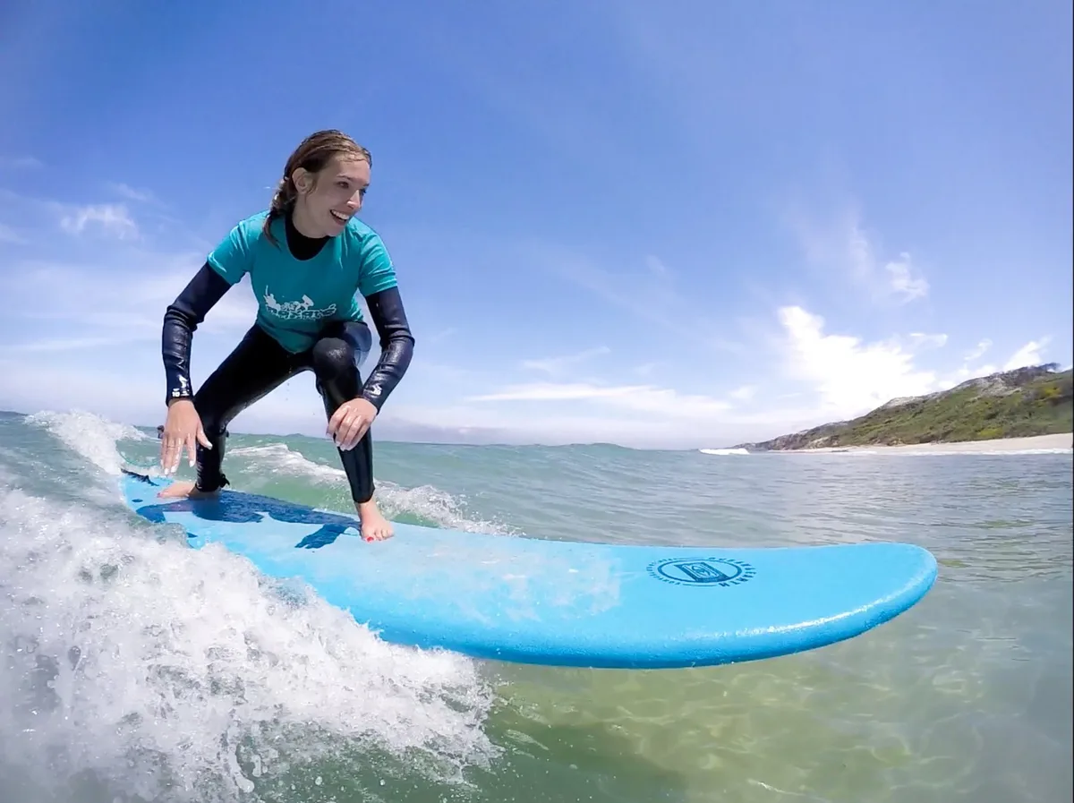 Student riding a wave on a Nazare Surf School board, captured by the school photographer